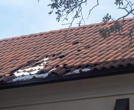 Expert roofer replacing broken roof tiles on the Gold Coast, ensuring roof integrity