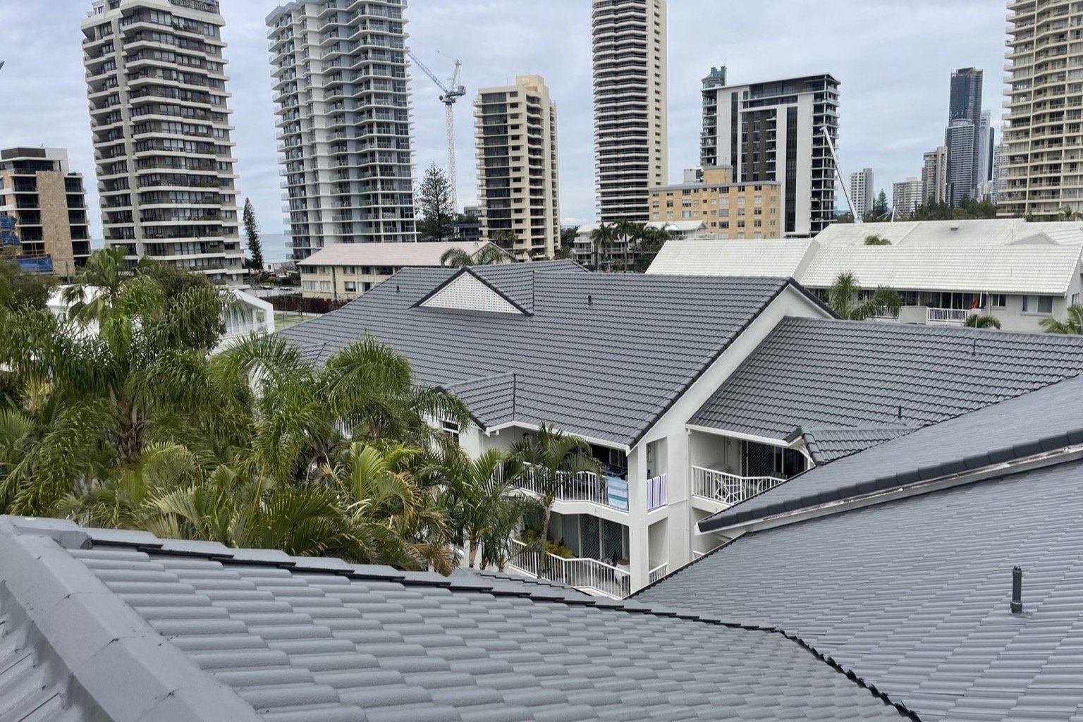 Charcoal tiled roofs on a Gold Coast townhouse complex with Surfers Paradise high rises behind
