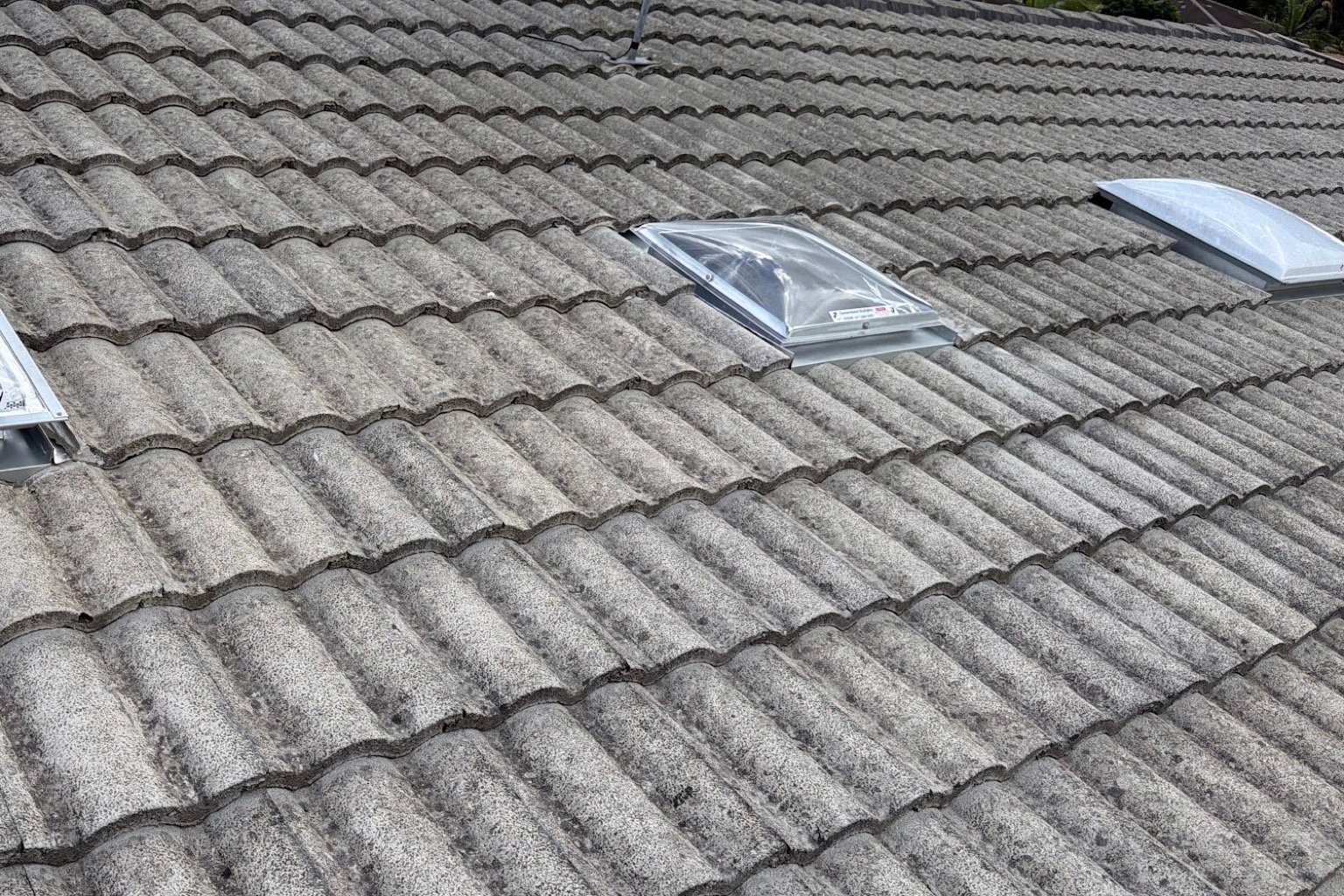Three skylights installed into a weathered concrete tiled roof in Brisbane